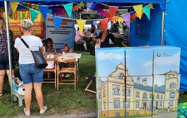 Stoisko Biblioteki podczas festynu w Przyszowicach. Na pierwszym planie puzzle.