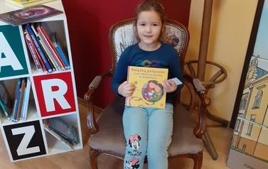 Dziewczynka z książką w bibliotece