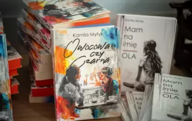Na zdjęciu dwie książki leżące na stoliku.