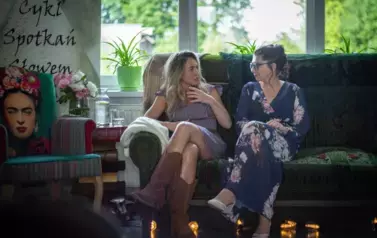 Dwie kobiety siedzące na kanapie.