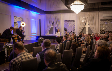 Szczepan Twardoch i Adam Zasada siedzą na fotelach. a przed nimi publiczność.