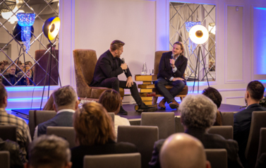 Szczepan Twardoch i Adam Zasada siedzą na fotelach. a przed nimi publiczność.