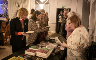 Dwie osoby oglądające stoisko z książkami.