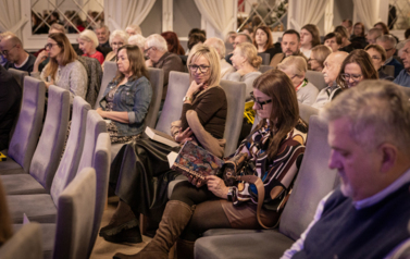 ludzie siedzący na sali podczas spotkania autorskiego