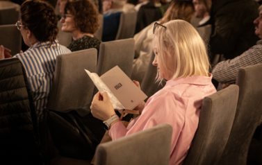 kobieta siedzi na krześle i czyta książkę