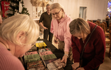 Na pierwszym planie kobiety oglądające książki.